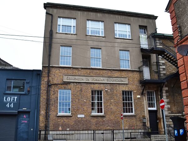 Exterior photograph of CBS Westland Row, a period brick facade with white panelled sash window, granite steps and window sills, with black railings at the front of the building.