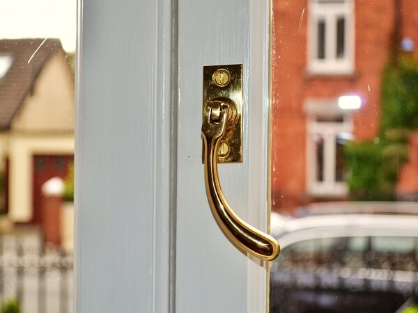 Close-up photograph of brass fastner, in new double glazed casement window.