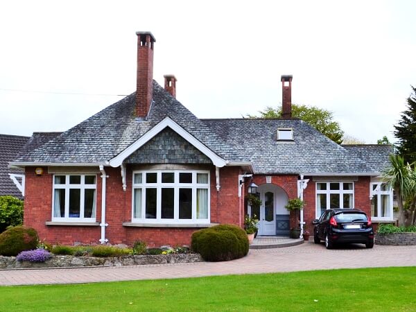 Photograph of a Dublin period home red brick facade featuring new white double glazed casement windows with granite windows sills.