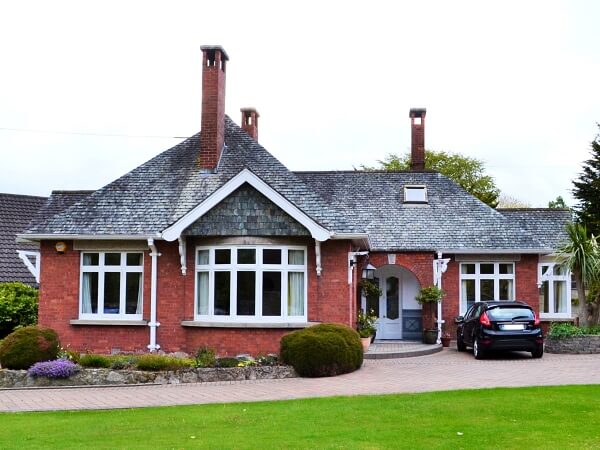 Photograph of a Dublin period home red brick facade featuring new white double glazed casement windows with granite windows sills.
