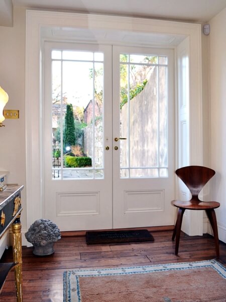 Photograph of new period white panelled french doors with shutters and architrave.